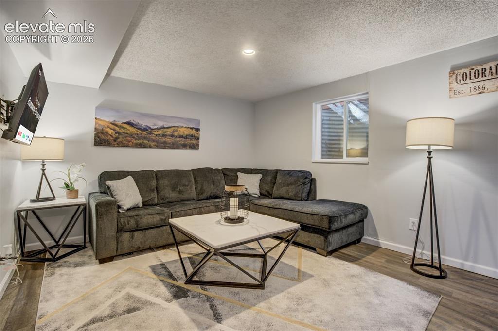 Image 21 of 50: Recessed lighting, wood-finish flooring, and a low-profile window