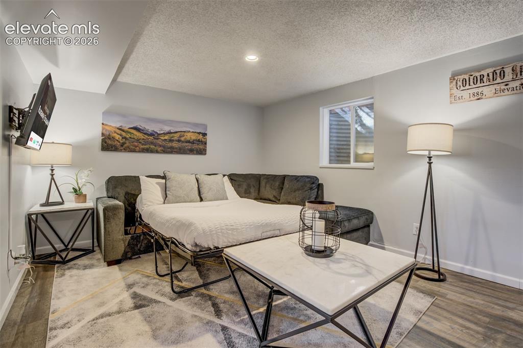 Image 22 of 50: Recessed lighting illuminates the space, featuring wood-finish flooring and