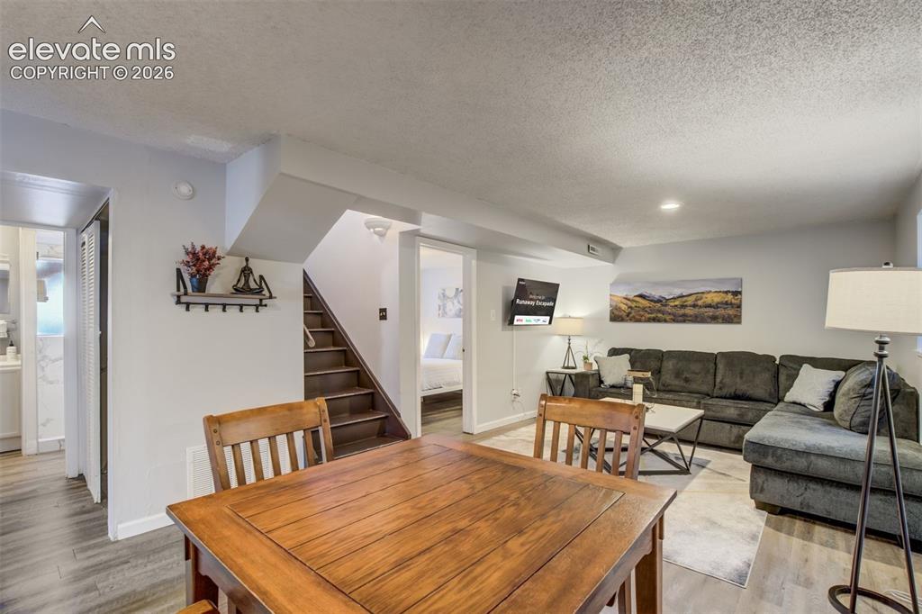Image 27 of 50: Wood-finish flooring, recessed lighting, and a built-in staircase