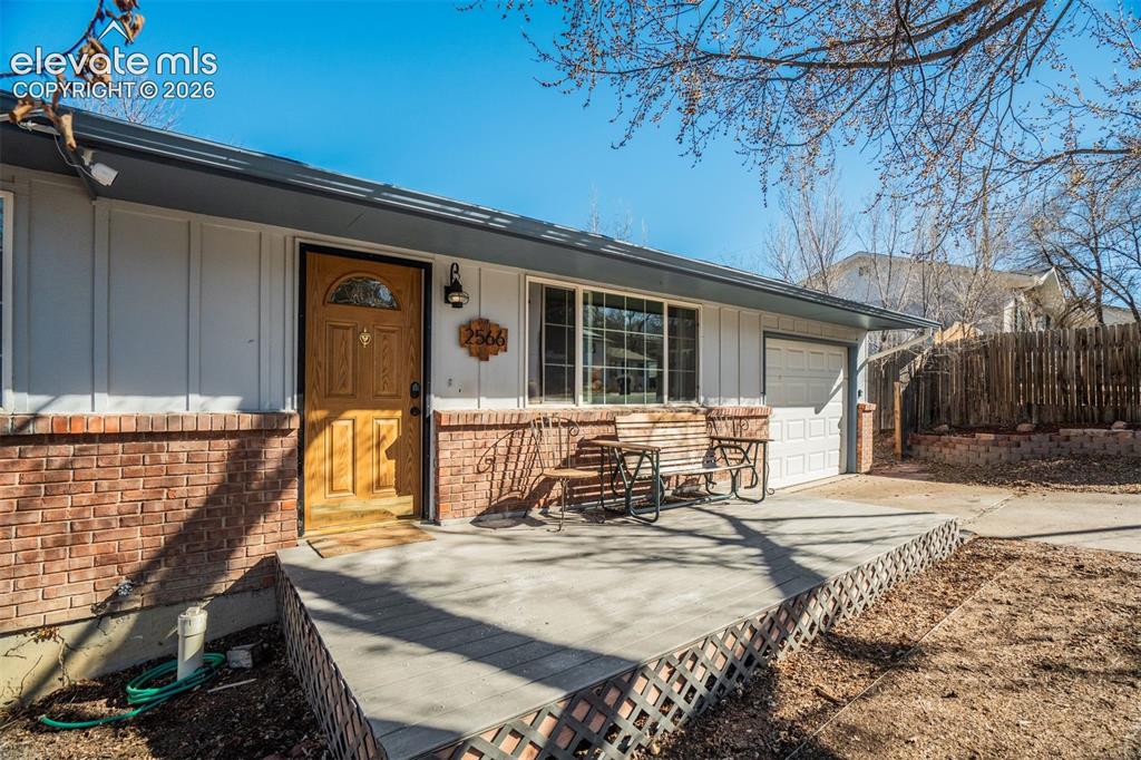 Image 3 of 50: Exterior featuring brick accents, white siding, and a wooden front door wit