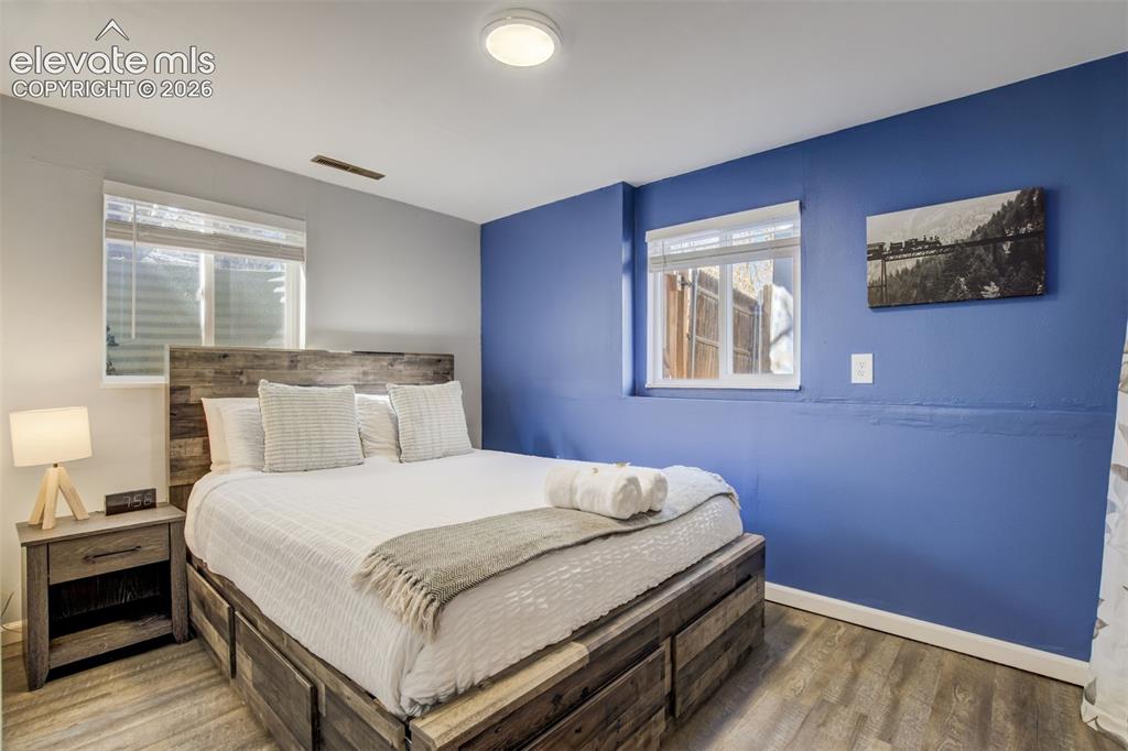 Image 31 of 50: Wood-finish flooring, accent wall, wood-finish bed frame, built-in window, 