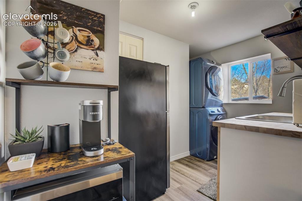 Image 34 of 50: Stacked washer and dryer, stainless steel sink, wood-finish countertops, wo