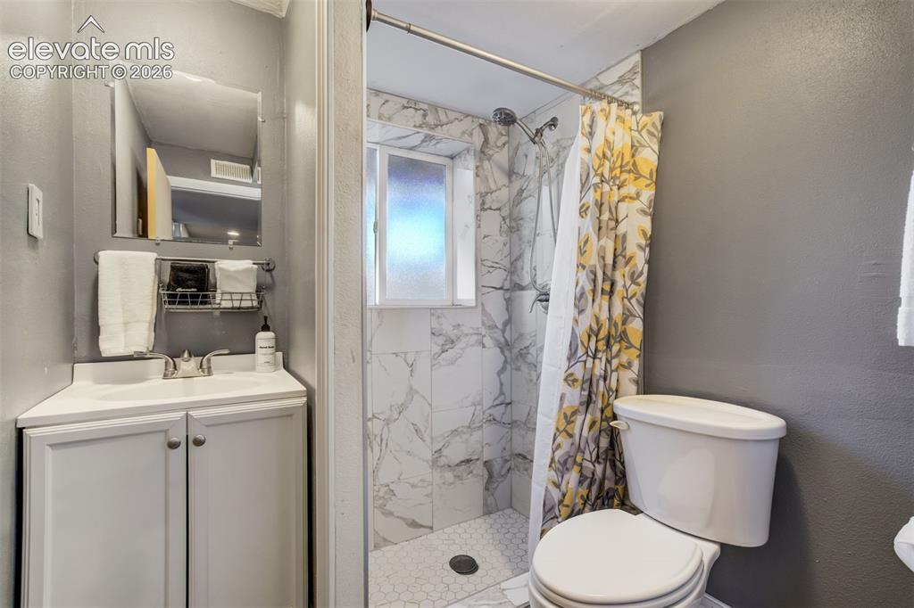 Image 37 of 50: White vanity with a rectangular sink and chrome faucet