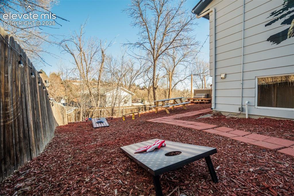 Image 38 of 50: Expansive outdoor area featuring a wood fence, string lighting, and a terra