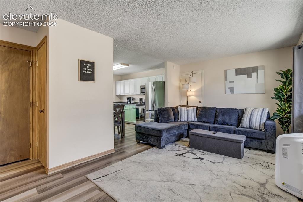 Image 4 of 50: Wood-finish flooring throughout, white wall paint, and a textured white cei