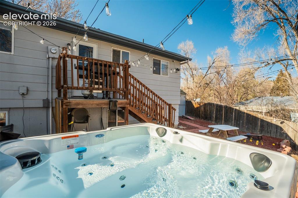Image 42 of 50: White outdoor hot tub with multiple jets