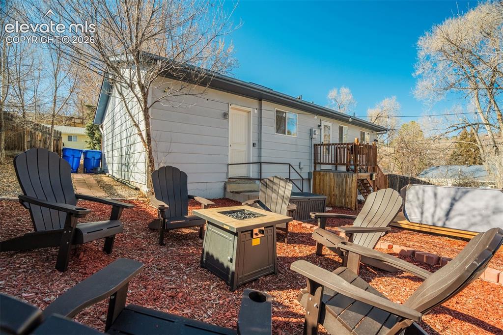 Image 45 of 50: Rear exterior featuring light-colored siding, a multi-level wood deck, and