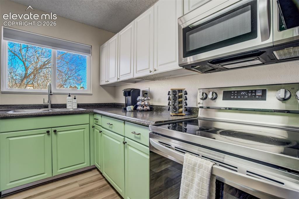 Image 9 of 50: Kitchen featuring a window, wood-finish flooring, stainless steel appliance