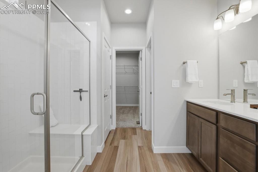 Image 16 of 34: Full bathroom featuring vanity, a spacious closet, light wood finished floo
