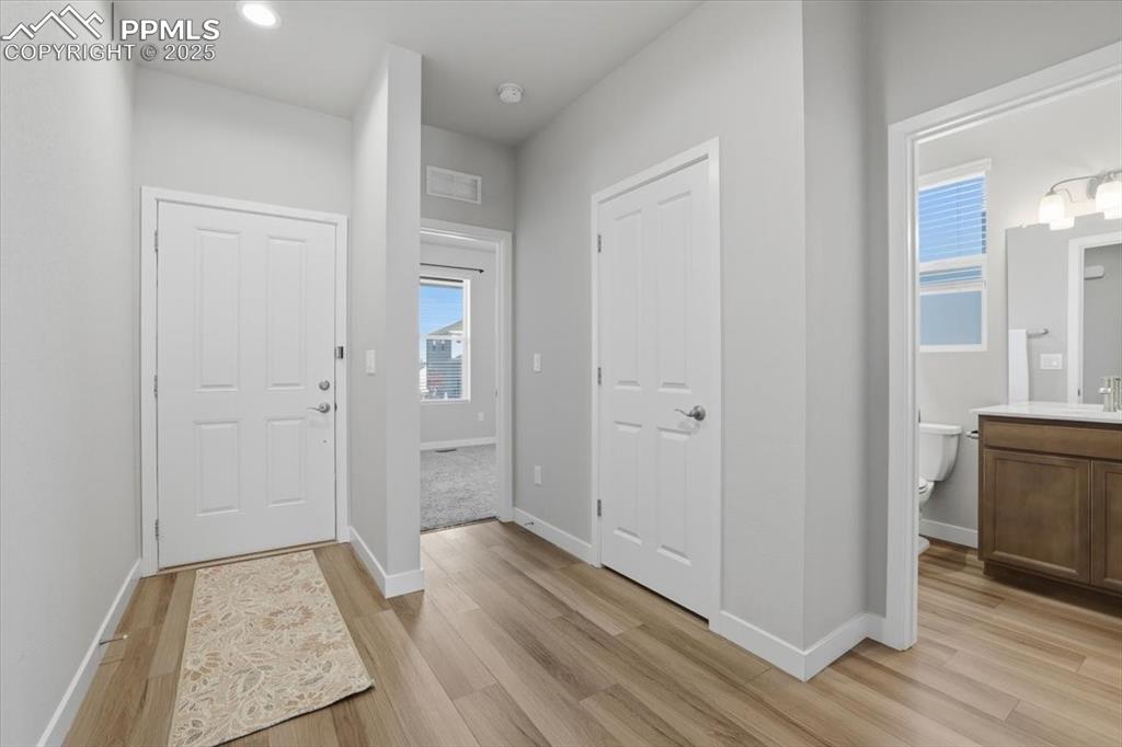 Image 20 of 34: Foyer with light wood finished floors and recessed lighting