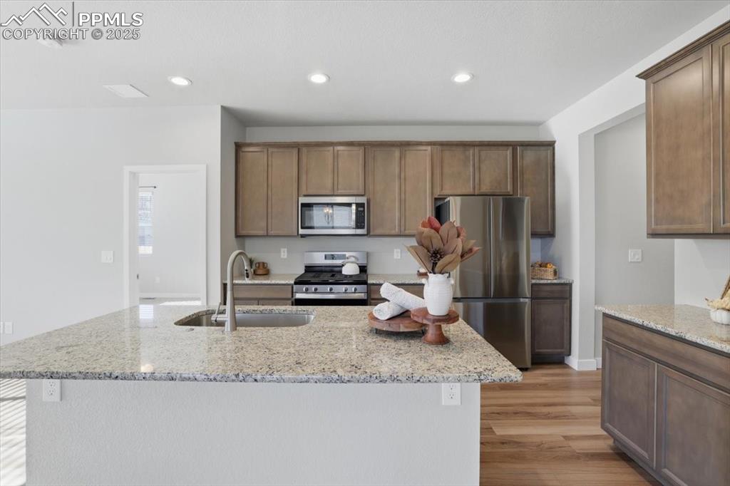Image 4 of 34: Kitchen with appliances with stainless steel finishes, light wood finished 