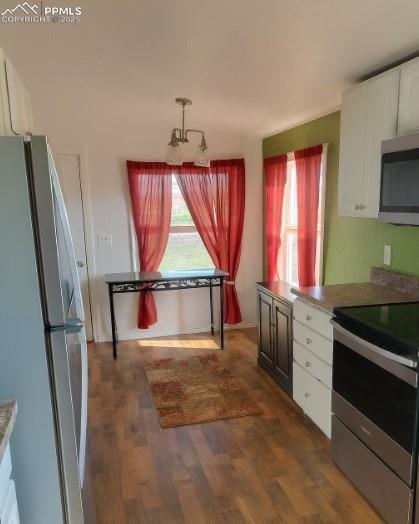Image 3 of 9: Kitchen with white cabinets, appliances with stainless steel finishes, dark
