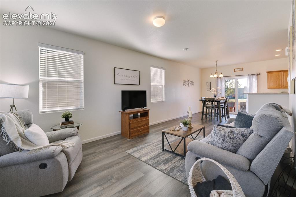 Image 10 of 36: Open-concept living area featuring wood-finish flooring, recessed lighting,