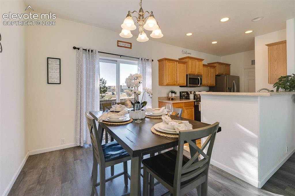 Image 13 of 36: Wood-finish flooring, sliding glass door, recessed lighting, and a kitchen 