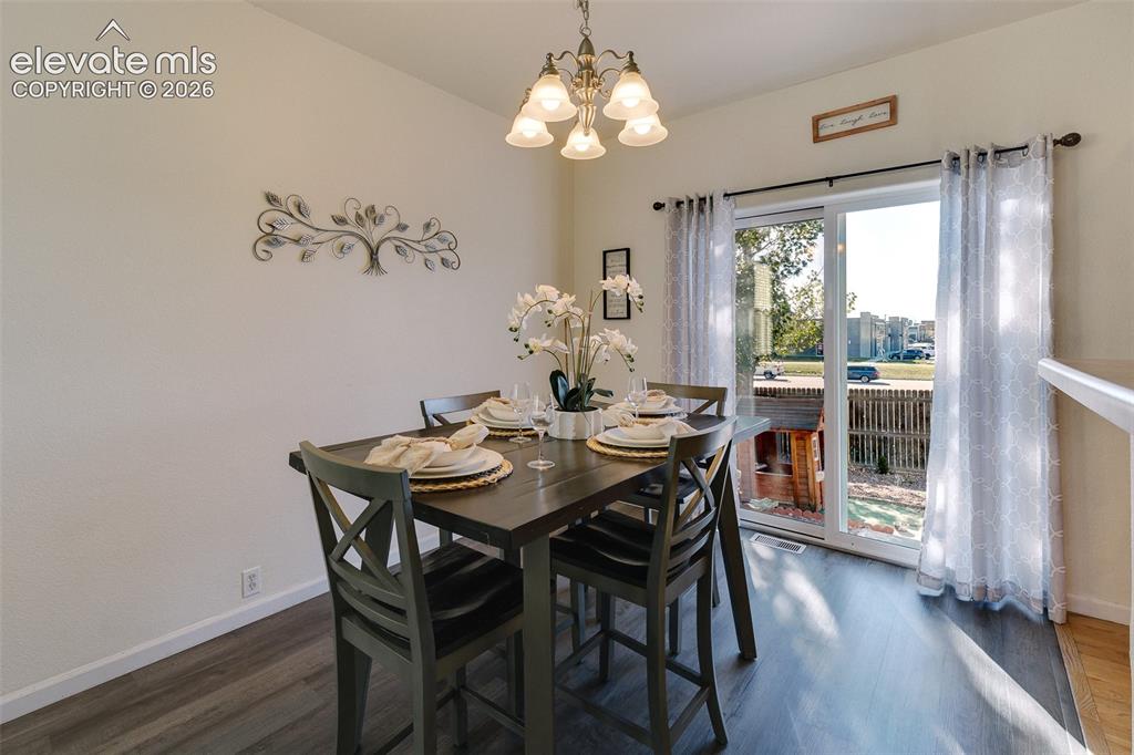Image 14 of 36: Dining area featuring a contemporary chandelier, wood-finish flooring, and