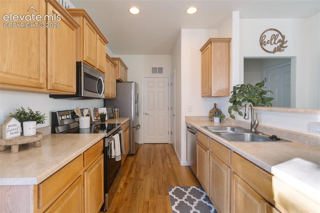 Image 15 of 36: Kitchen featuring light wood cabinetry, light-toned countertops, stainless