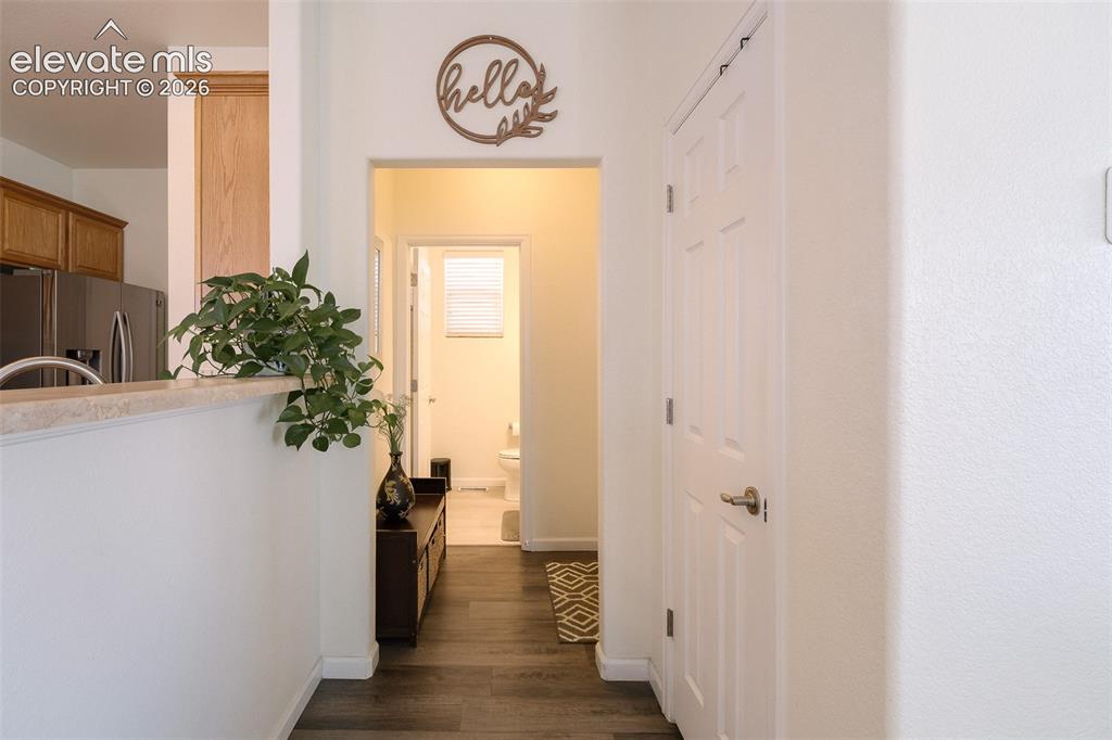Image 17 of 36: Hardwood-style flooring throughout, white interior walls, kitchen with wood