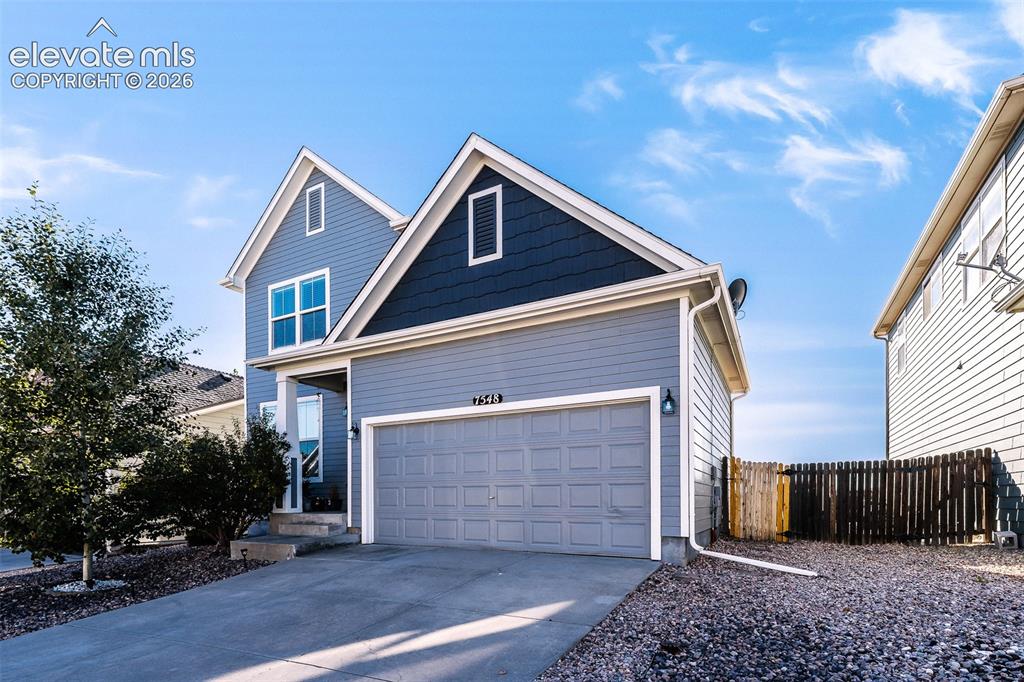 Image 2 of 36: Two-story exterior with multi-toned siding, attached garage, and a fenced s