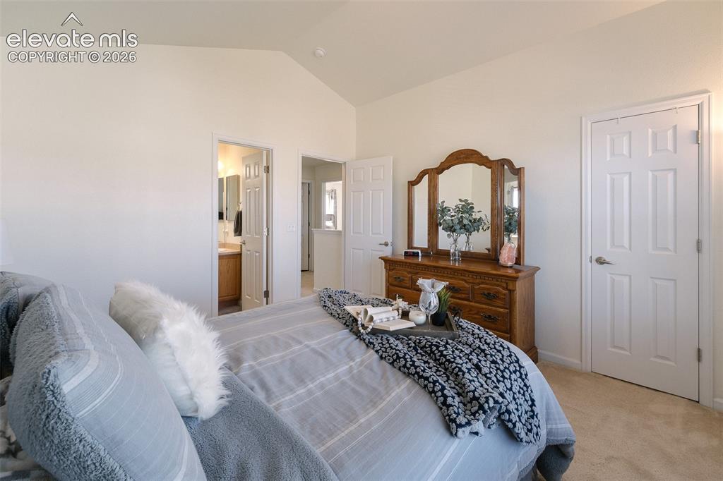 Image 22 of 36: Vaulted ceiling, carpeted flooring, white interior doors, neutral wall tone