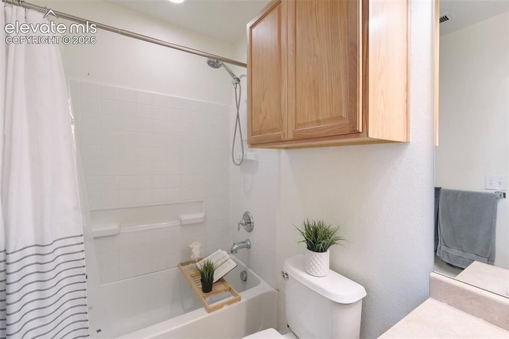 Image 23 of 36: White subway tile shower surround with a built-in tub, recessed lighting, a
