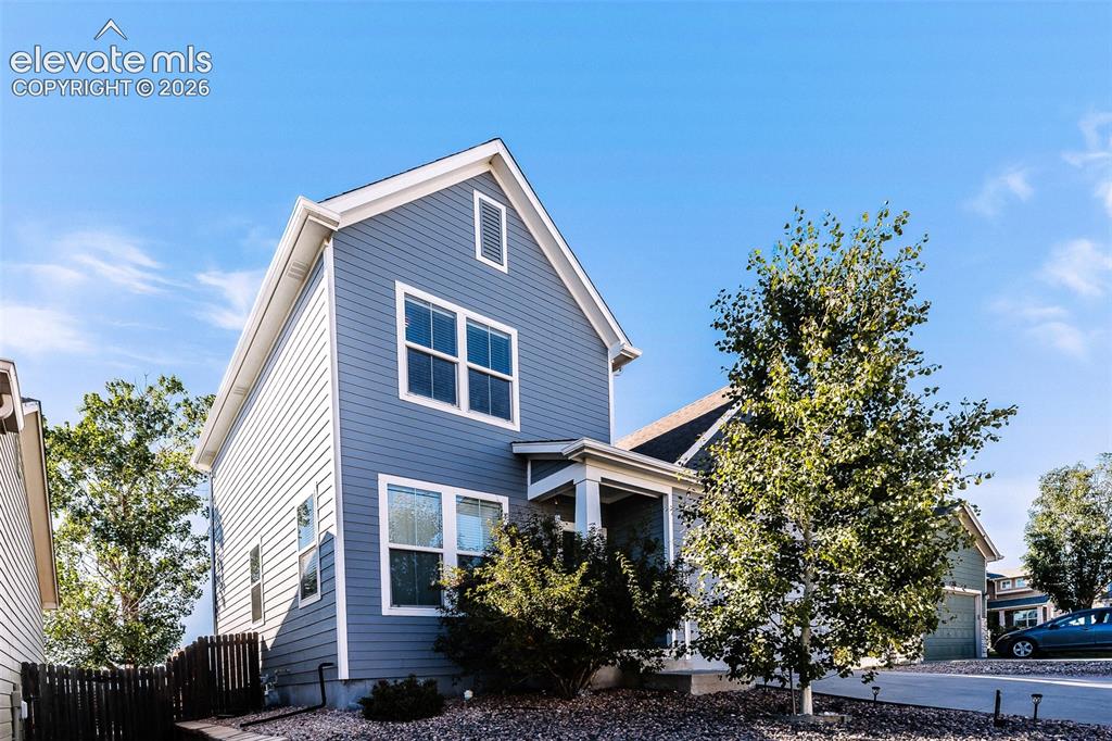 Image 3 of 36: Two-story exterior with blue horizontal siding and white trim
