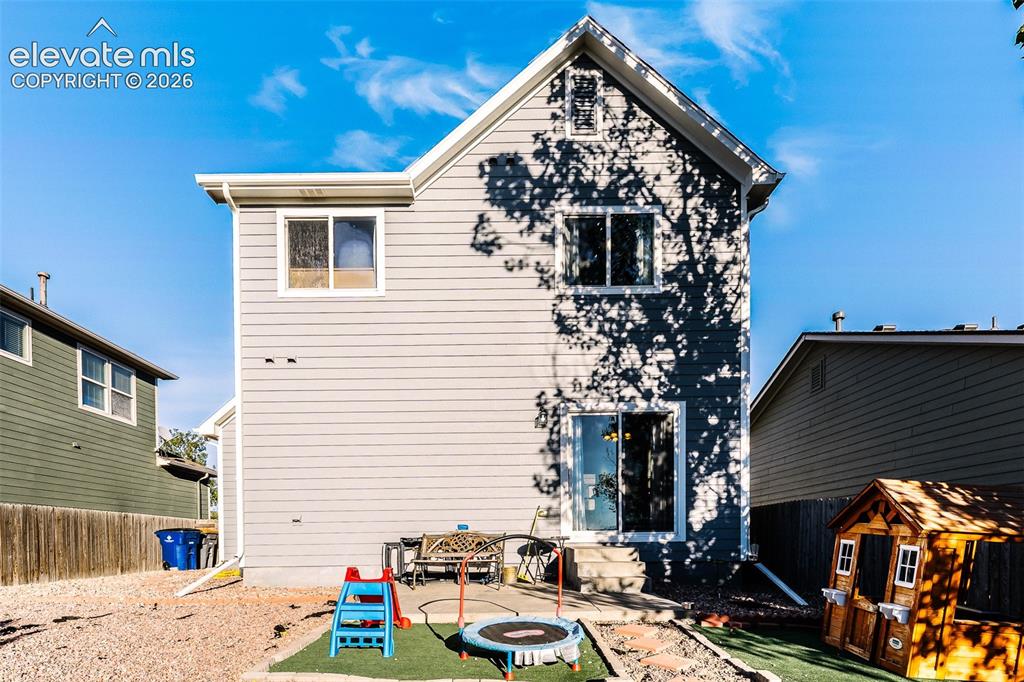 Image 32 of 36: Exterior featuring light gray siding, white trim, multiple windows, a slidi