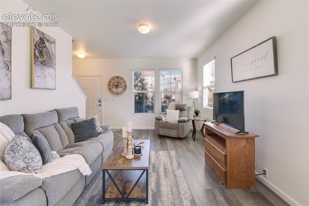 Image 5 of 36: Recessed lighting, wood-finish flooring, white paneled door, and multiple w