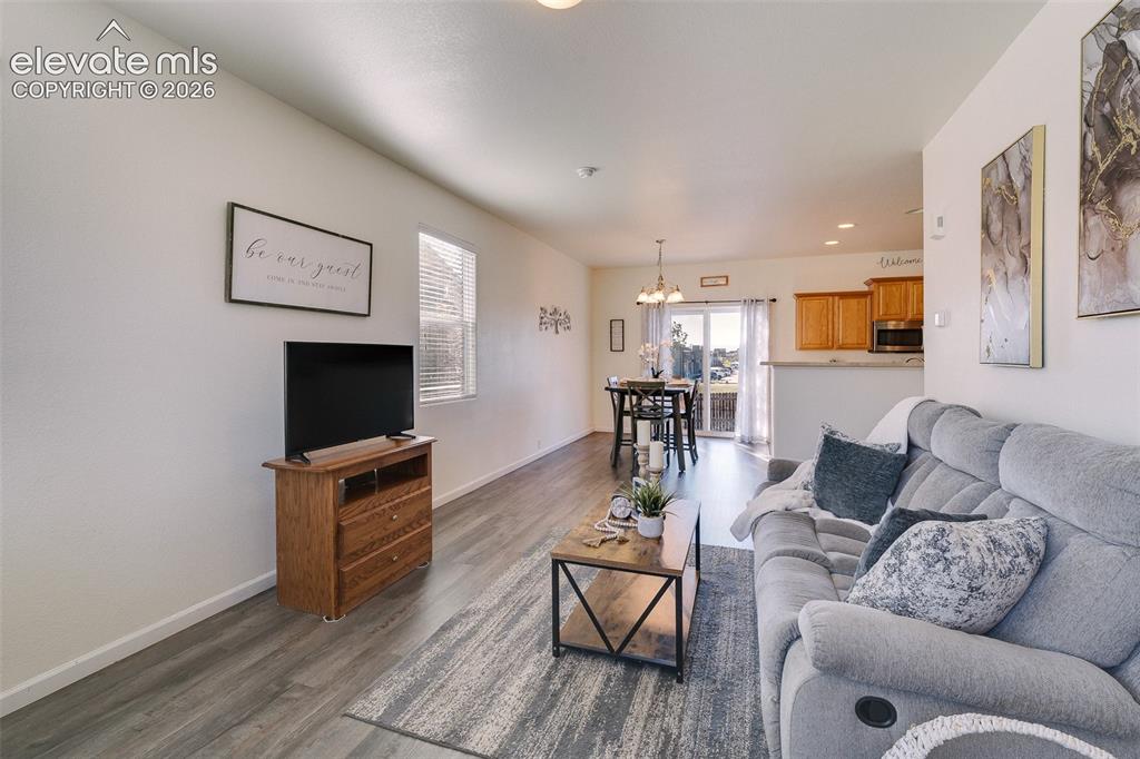 Image 6 of 36: Wood-finish flooring throughout, with a dining area featuring a pendant lig