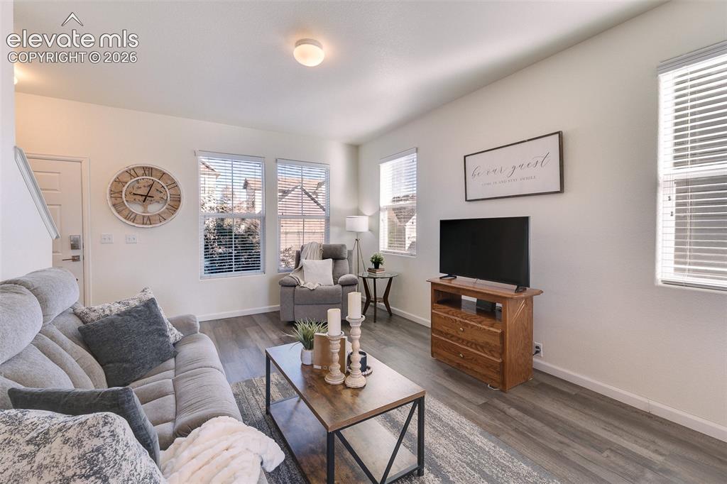 Image 9 of 36: Wood-finish flooring, multiple windows with horizontal blinds, and a wood m