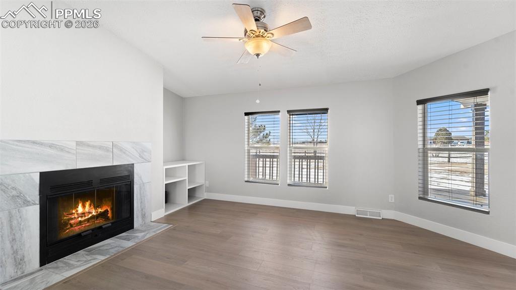 Image 35 of 50: Unfurnished living room featuring ceiling fan, plenty of natural light, a f