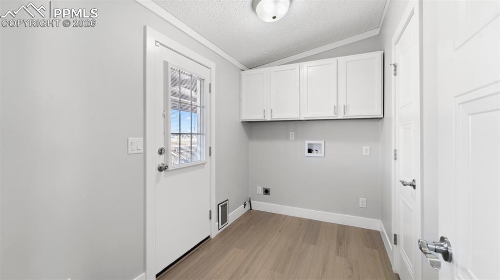 Image 41 of 50: Laundry area with cabinets, light hardwood / wood-style floors, hookup for 