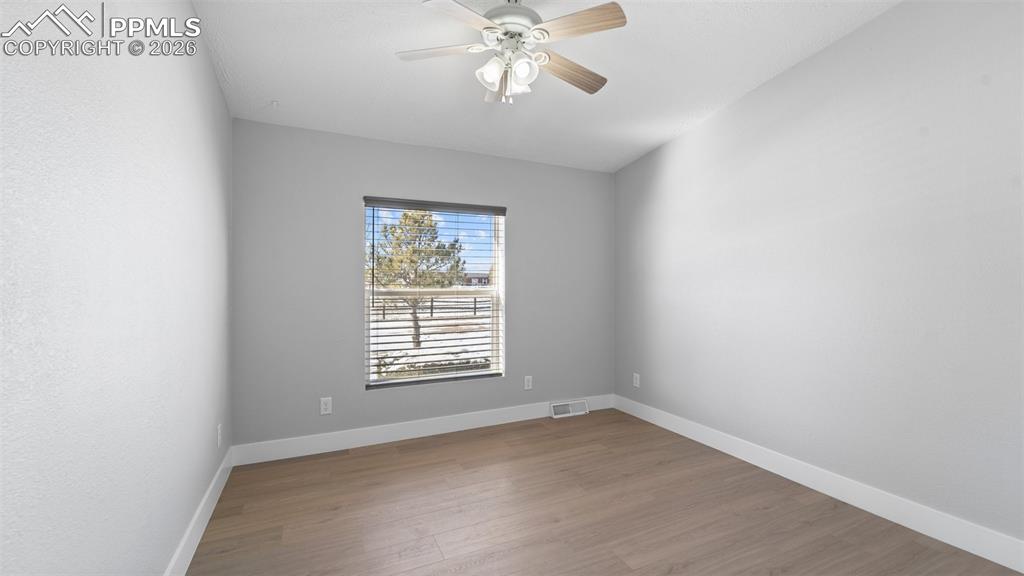 Image 44 of 50: Spare room with hardwood / wood-style flooring and ceiling fan