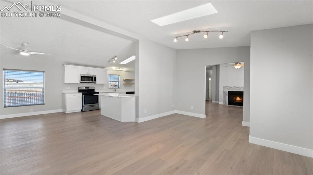 Image 49 of 50: Kitchen with appliances with stainless steel finishes, vaulted ceiling with