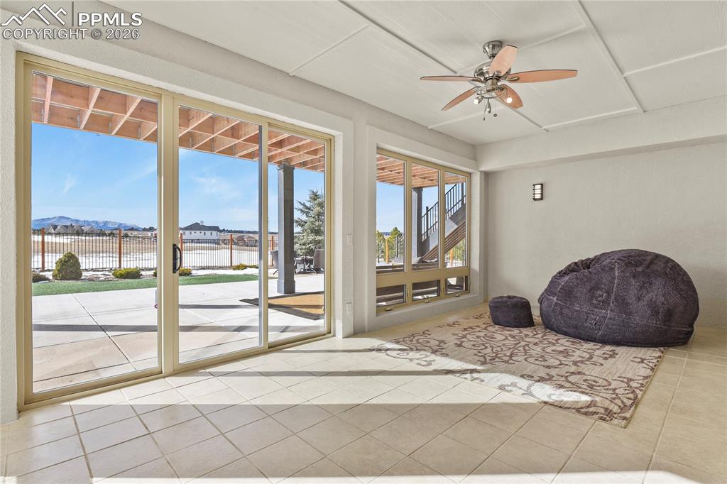 Image 33 of 50: Lower level sun room walks out to patio, both covered and uncovered areas
