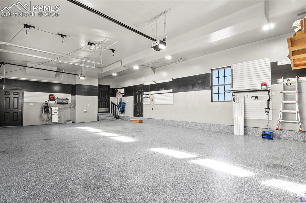 Image 38 of 50: 4-car garage with epoxy coated floors, new insulated garage doors and opene