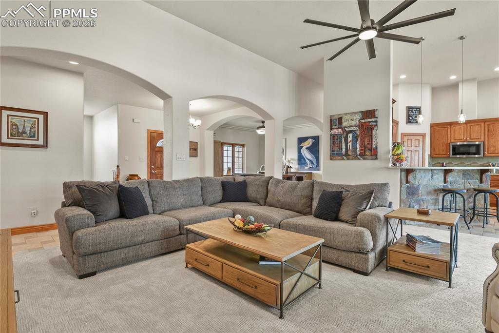 Image 7 of 50: Great room with arched entries, tall ceilings, new carpet