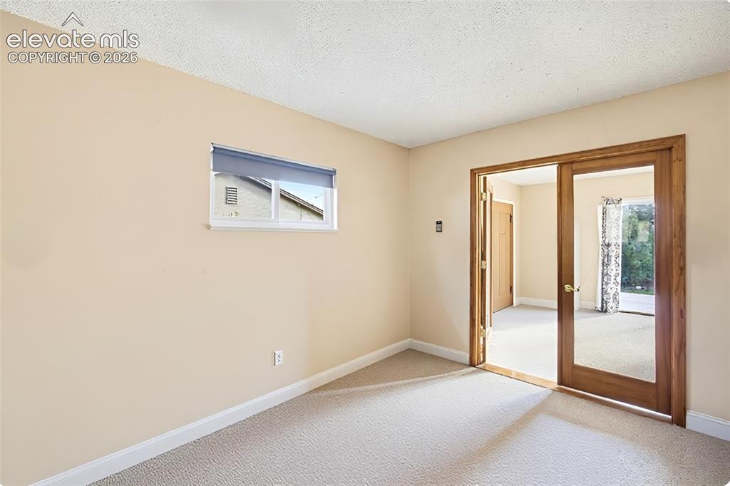 Image 29 of 42: Adjoining living room with walkout and fireplace