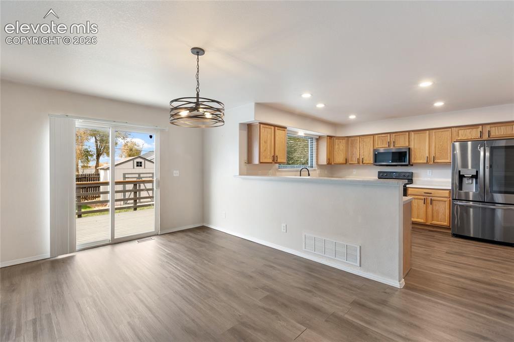 Image 11 of 38: Open-concept living space featuring wood-finish flooring, a contemporary dr