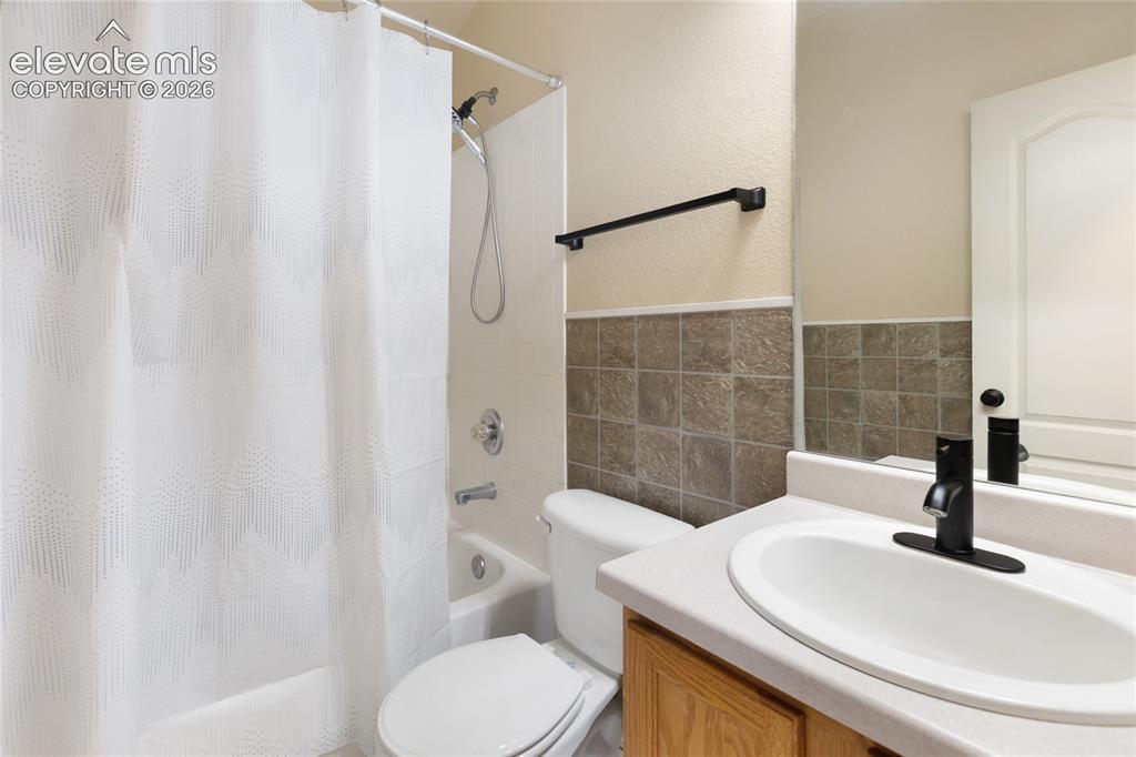 Image 26 of 38: Bathroom featuring a white bathtub and shower combination, a toilet, and a 