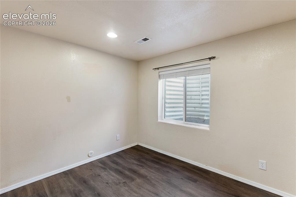 Image 34 of 38: Room featuring wood-finish flooring, recessed lighting, and a window with b