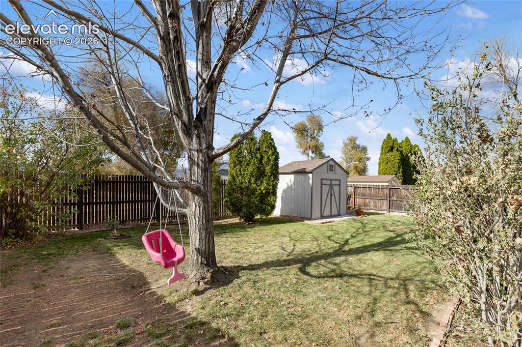 Image 5 of 38: Expansive outdoor space featuring a manicured lawn, established trees, and 