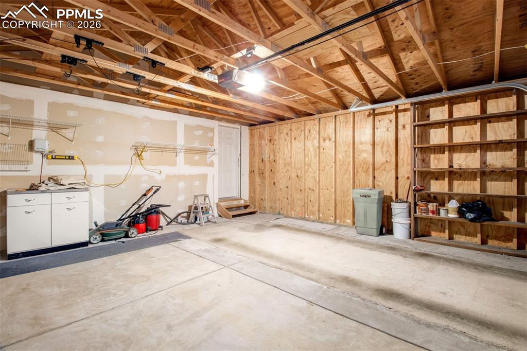 Image 19 of 26: Large 2 car garage with built-in shelving