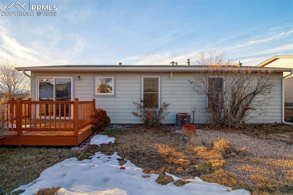Image 20 of 26: Back of the home with a wood deck to enjoy the outdoor space