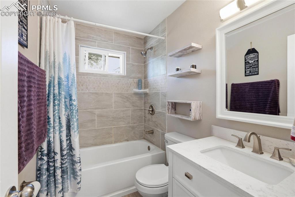 Image 11 of 19: Bathroom featuring a white bathtub, tiled shower walls, a window, and a van