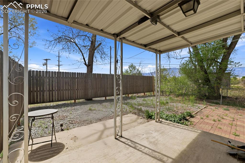 Image 13 of 19: The property features a covered patio with a concrete floor and decorative 