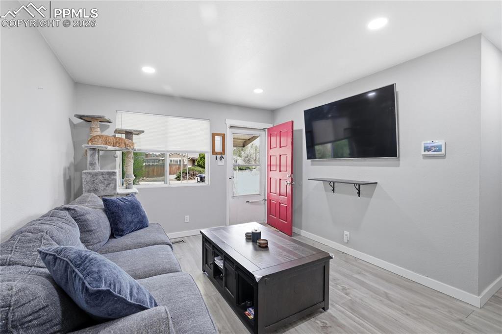 Image 3 of 19: Living area featuring light gray walls, recessed lighting, and wood-look fl