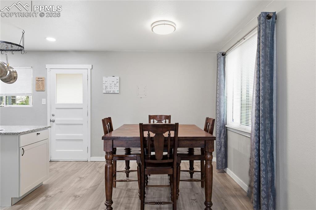 Image 6 of 19: Dining area with light wood-look flooring, a window with blinds, and recess
