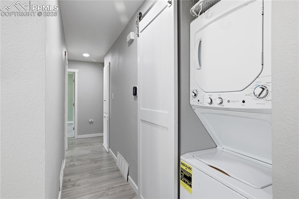 Image 7 of 19: Hallway featuring light gray walls, light wood-style flooring, and a barn d