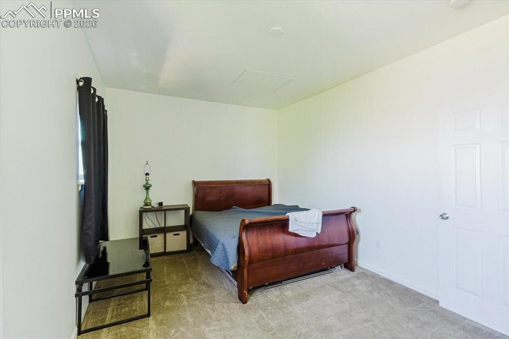 Image 10 of 35: Carpeted interior room featuring a window with dark drapes, white walls, an