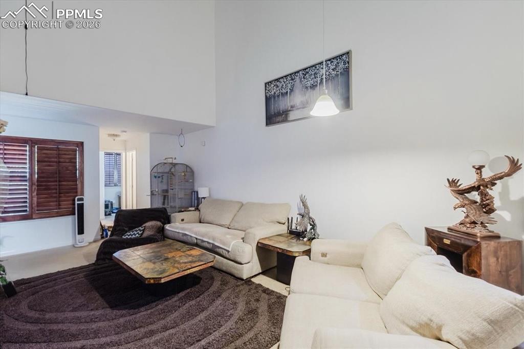 Image 13 of 35: High ceilings with a dedicated pendant light fixture, a window featuring wo